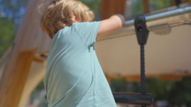 Menino Escalando Estrutura Playground Fora Durante Dia Ensolarado Brilhante Miúdo — Vídeo de Stock