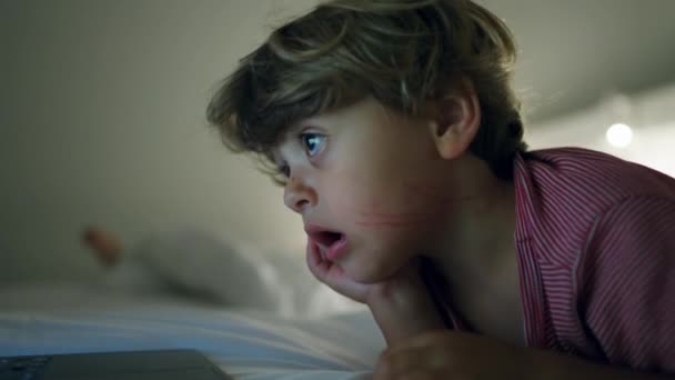 Ребенок Смотрит Развлекательные Программы Экране Ноутбука Лежа Постели Ночам Загипнотизированный — стоковое видео