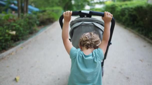 Schattig Kind Helpt Kinderwagen Naar Buiten Duwen Het Park Familievakanties — Stockvideo