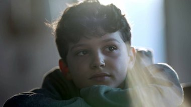 One thoughtful small boy daydreaming. Preteen child closeup face in contemplation. Pensive dreamy