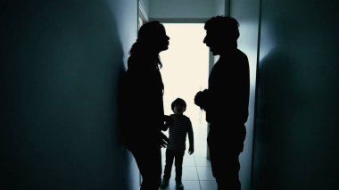 Angry parents fighting in front little boy son. Abusive relationship discussion. Husband hitting wife standing in corridor in the dark