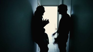 Angry parents fighting in front little boy son. Abusive relationship discussion. Husband hitting wife standing in corridor in the dark