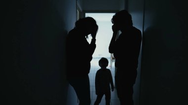 Silhouette of couple standing in corridor in crisis. Parents with child feeling worry and anxiety. Husband and wife discussing difficult situation
