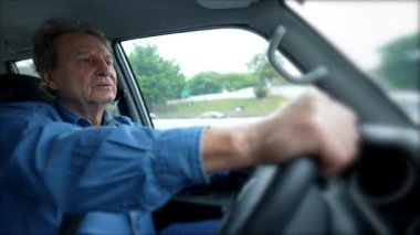 Person driving car on road holding steering wheel. Male caucasian mature senior person driver