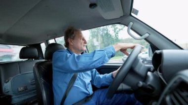 One older man driving in city in moving vehicle. Retired senior male caucasian person driver holding car steering wheel