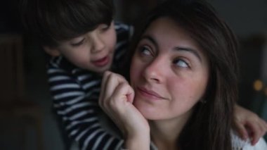 Mother and child embrace. Little boy son hugging mom from the back and kissing on cheek. Family lifestyle love and affection