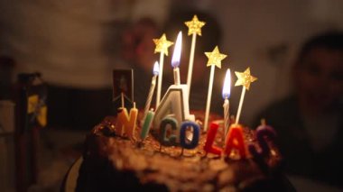 Birthday cake anniversary celebration with candles close up with the name nicolas written on top. 4 years old number