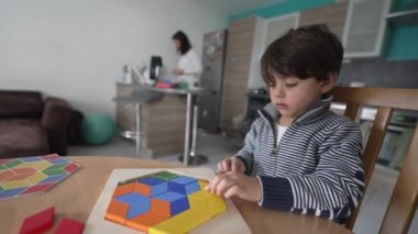 Evde bulmaca bloklarıyla oynayan yaratıcı çocuk. 3 yaşında küçük bir çocuk ev içinde kendi kendine oynamayı öğreniyor.