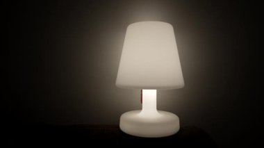 One Lamp glowing light in dark. Bedside nightlamp