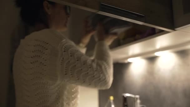 妇女组织家庭把储物箱放到厨房橱柜架上 — 图库视频影像