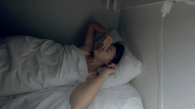 Woman turns light in the middle of the night unable to sleep. Person suffering from insomnia and stress feeling sleepless