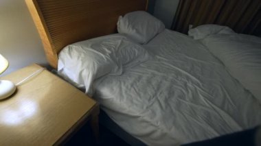 Person going to bed and sleep. Man lays down and turns off light besides bedside