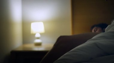 Man waking up getting out of bed in the middle of the night. Early wake up in the morning. Person starting the day routine