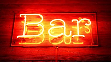İşletme girişinde kırmızı renkli bar floresan ışığı ve ahşap yüzey reklam işi el hareketinde.