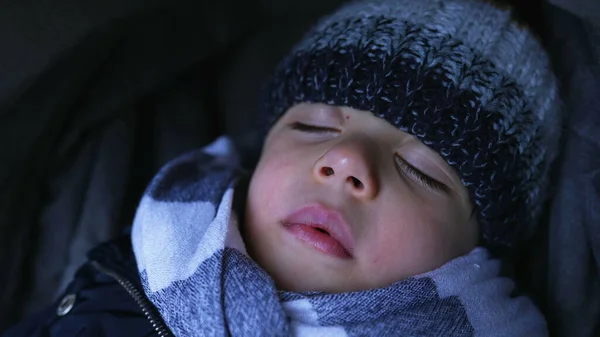 Closeup child face napping during winter season. Warm little boy asleep