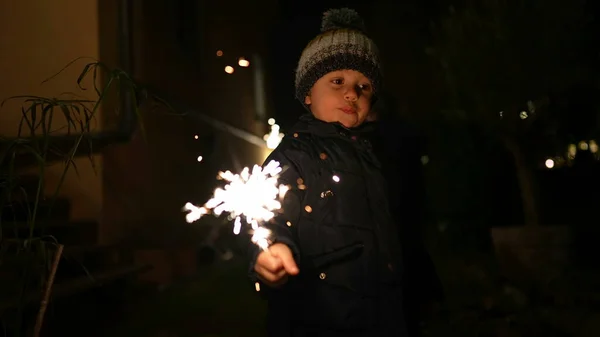 stock image One young boy holding sparkler at night. Happy child celebrating holidays