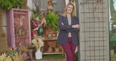 Portrait of a small business owner standing in front of shop store with arms crossed smiling. Female mature entrepreneur. Job occupation concept