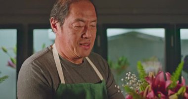 Happy entrepreneur of small business flower shop creating bouquet arrangement of flowers