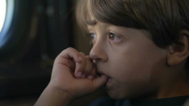 Ağzında başparmağı olan düşünceli bir çocuk trenle seyahat ederken düşünüyor. Düşüncelere dalmış küçük çocuğu kapat.
