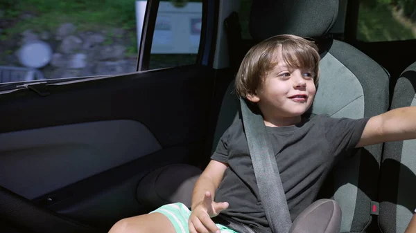 Ein Fröhlicher Kleiner Junge Der Auf Dem Rücksitz Des Autos — Stockfoto