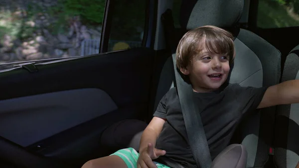 Ein Fröhlicher Kleiner Junge Der Auf Dem Rücksitz Des Autos — Stockfoto