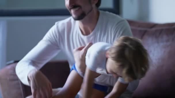 Father Embracing Little Son Arms Sitting Couch Home Dad Child — Stock Video