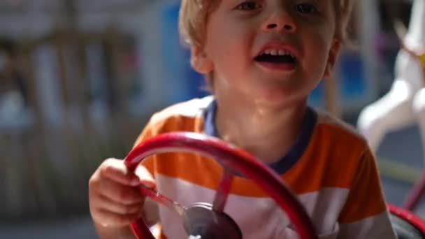 Fröhliches Kinderkarussell Fahren Großaufnahme Von Kind Mit Auto Spielzeuglenkrad Das — Stockvideo