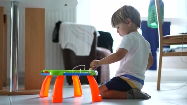 家の床でテーブルのおもちゃの絵のボードで遊ぶことができます 幼少期の発達ライフスタイル — ストック動画
