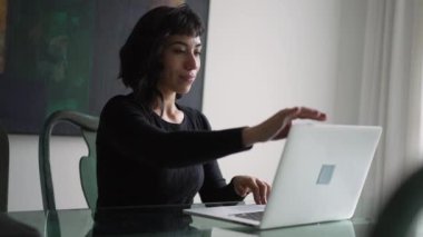 İspanyol bir kadın evde dizüstü bilgisayar açıyor. Güney Amerikalı kız modern teknolojiyle çalışıyor ya da çalışıyor