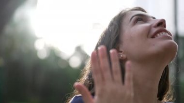 Evanjelik bir kadın dışarıda ayakta Tanrı 'ya dua ediyor. Dindar insan umutla ve inançla gökyüzüne bakıyor.