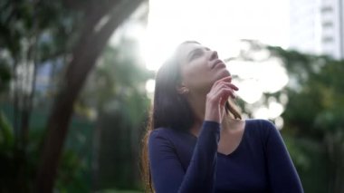 Dışarıda duran düşünceli bir kadın çözümü düşünüyor. Parkta ikilem yaşayan kız