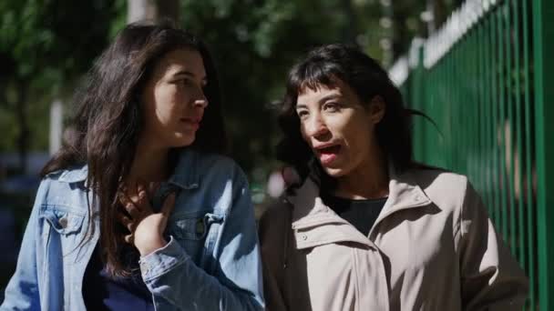 两个快乐的女性朋友一边笑着 一边在外面的城市街道上聊天 — 图库视频影像
