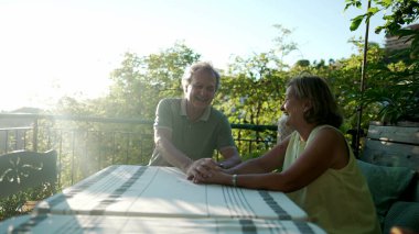 Gerçek hayatta kıdemli bir çift birlikte güler ve gülümser. Açık yürekli, olgun evli karı koca, evin bahçesinde el ele tutuşurken mutlu olun.