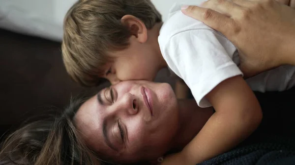 Dziecko Przytulające Matkę Leżącą Kanapie Domu Mały Chłopiec Położył Się — Zdjęcie stockowe