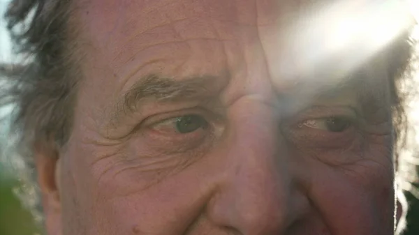 成熟した老人が顔と目を閉じて 太陽の光が外に出ています 古い男のマクロクローズアップカメラを見てしわの目を持つ人 — ストック写真