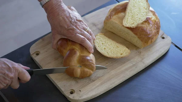 stock image Close up hand slicing brioche bread. Traditional European braided bread