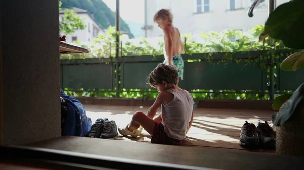 신발을 신발에 놓는아이 바닥에 아이가 테니스 신발을 — 스톡 사진