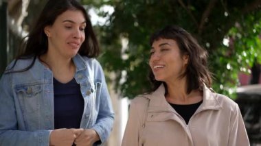 Sokakta yürürken kadınlar konuşuyor. Şehir kaldırımında sohbet eden iki kız arkadaş.