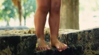 Parktaki çamurlu su birikintisine sıçrayan oyuncu çocuk. Çocuk havuza atlıyor.