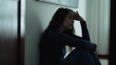 Endişeli kadın yerde oturuyor ve sinir krizi geçiriyor. Endişeli ve endişeli bir insan evde sorunlarla boğuşuyor