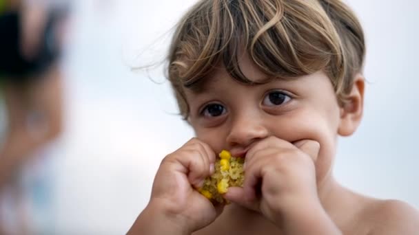 Один Маленький Мальчик Ест Кукурузную Закуску Портрет Лица Крупным Планом — стоковое видео