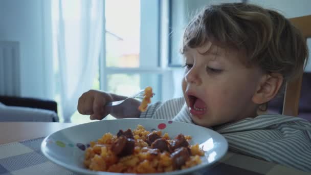 子供の熱い食べ物燃焼口を食べる 一人の小さな男の子が皿の上でパスタを吐き出した 子供は昼食を食べる — ストック動画