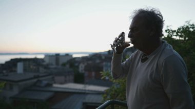 Son sınıflardan biri gün batımında şarap içiyor. Emekliliğin tadını çıkarırken manzaraya bakan düşünceli bir yaşlı.