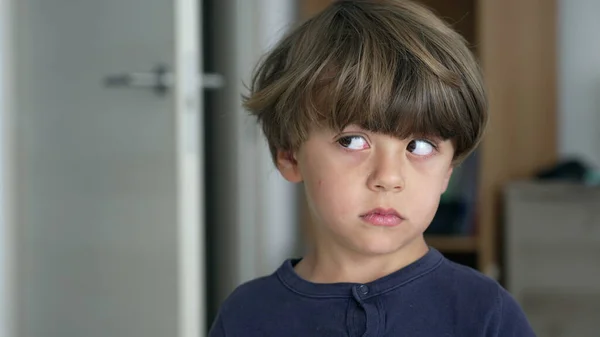 一个忧心忡忡的小男孩的画像 侧视着思考 一个站在室内的孩子的近脸 脸上带着沉思的表情 — 图库照片