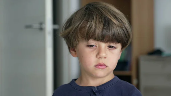 横に思考を探している1つの普及した少年の肖像画 思慮深い表情で屋内に立つ子供の顔を閉じてください — ストック写真