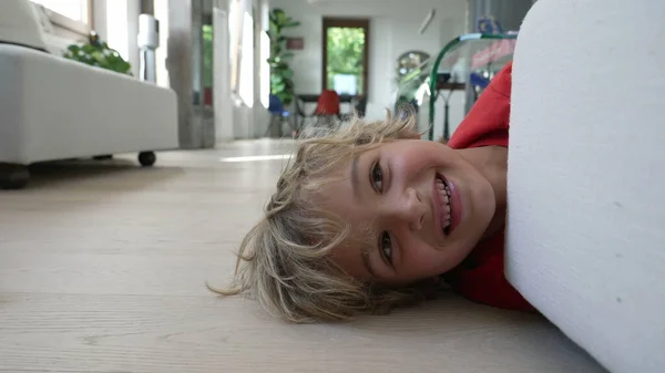 Один Щасливий Маленький Хлопчик Лежить Підлозі Ховається Диваном Сучасній Домашній — стокове фото