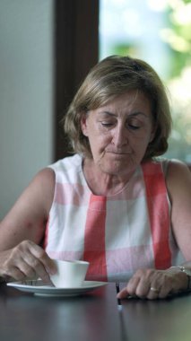 Kahveli espresso yudumlayan yaşlı kadın. Yaşlı bir kadın kahve içiyor. 