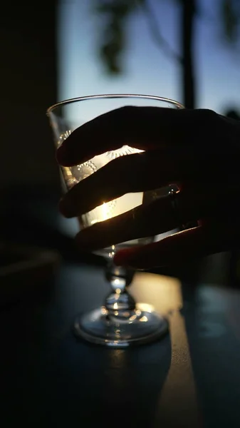 Κοντινό Χέρι Μαζεύοντας Λευκό Ποτήρι Κρασιού Έξω Στο Ηλιοβασίλεμα — Φωτογραφία Αρχείου
