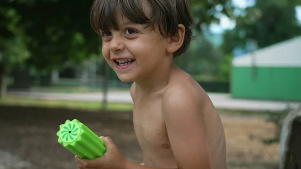 夏の日に屋外でおもちゃの楽しみと水を噴霧1つの幸せな男の子 興奮した若い子供たちは泡水ブラスターで外で遊んでいます スイミングプールのおもちゃ — ストック写真