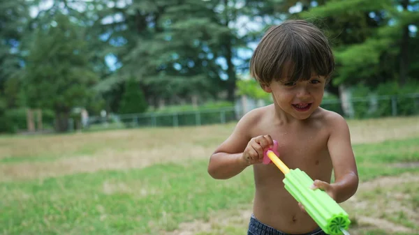 一个快乐的小男孩在户外喷水玩乐 兴奋的小孩在外面玩泡沫水爆竹 游泳池玩具 — 图库照片